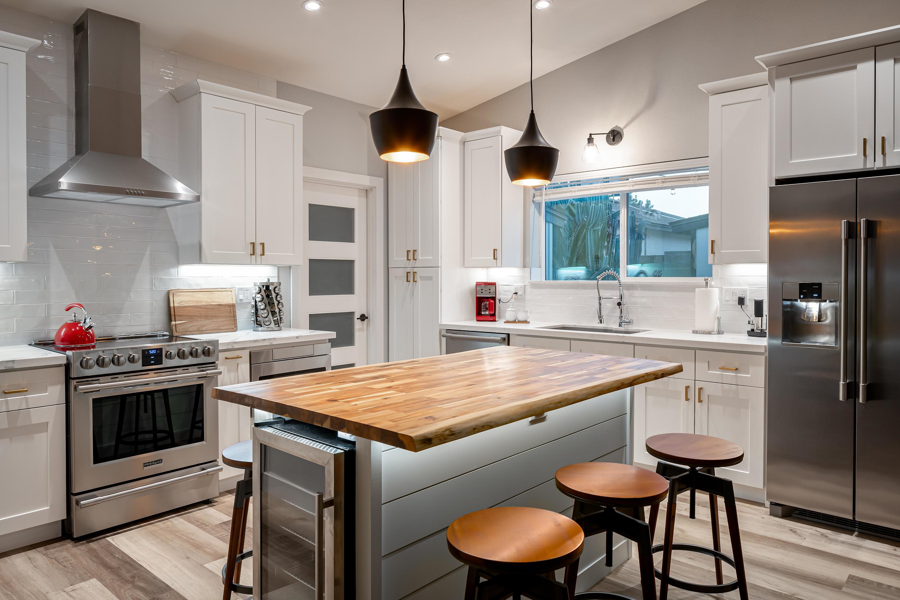 A modern chef's kitchen design with mini fridge built into the island.