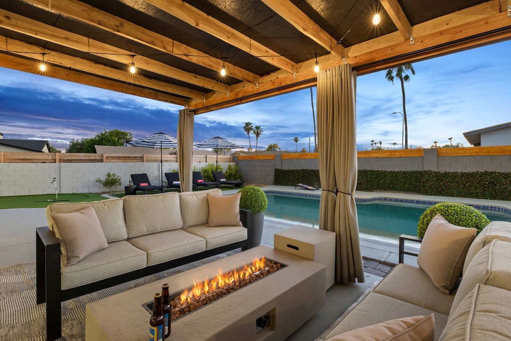 Cozy outdoor seating area with a fire pit and poolside views, perfect for evening gatherings.