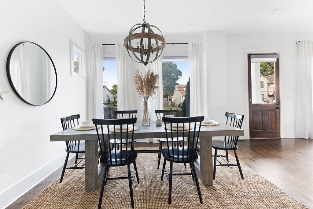 The farmhouse table with six chairs in the dining area is perfect for a breakfast setup or hosting a delightful dinner party.