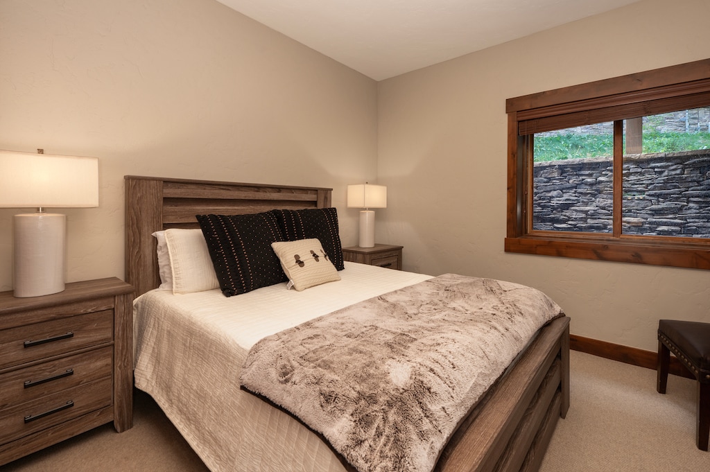 - Retreat to this cozy bedroom with warm neutral tones, plush blankets, and soft textures - Window with forest views adds a peaceful touch to the quiet ambiance - Perfect guest suite or private nook for deep sleep and tranquil nights