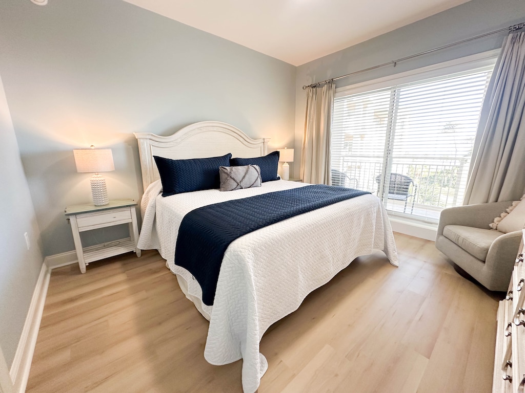 This spacious primary bedroom offers a calm, coastal retreat with soft natural light and a soothing color palette.