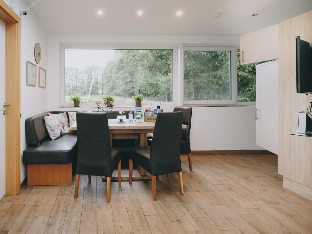 Dining room in the holiday apartment by we rent apartments, with a table, corner bench, and three chairs. Mountain view.