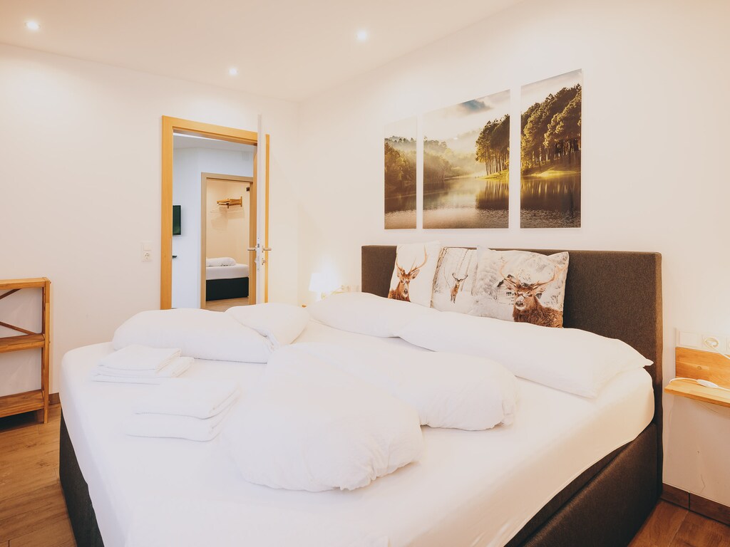 Bedroom in the holiday apartment by we rent apartments, featuring a cozy double bed with a nature poster on the wall.