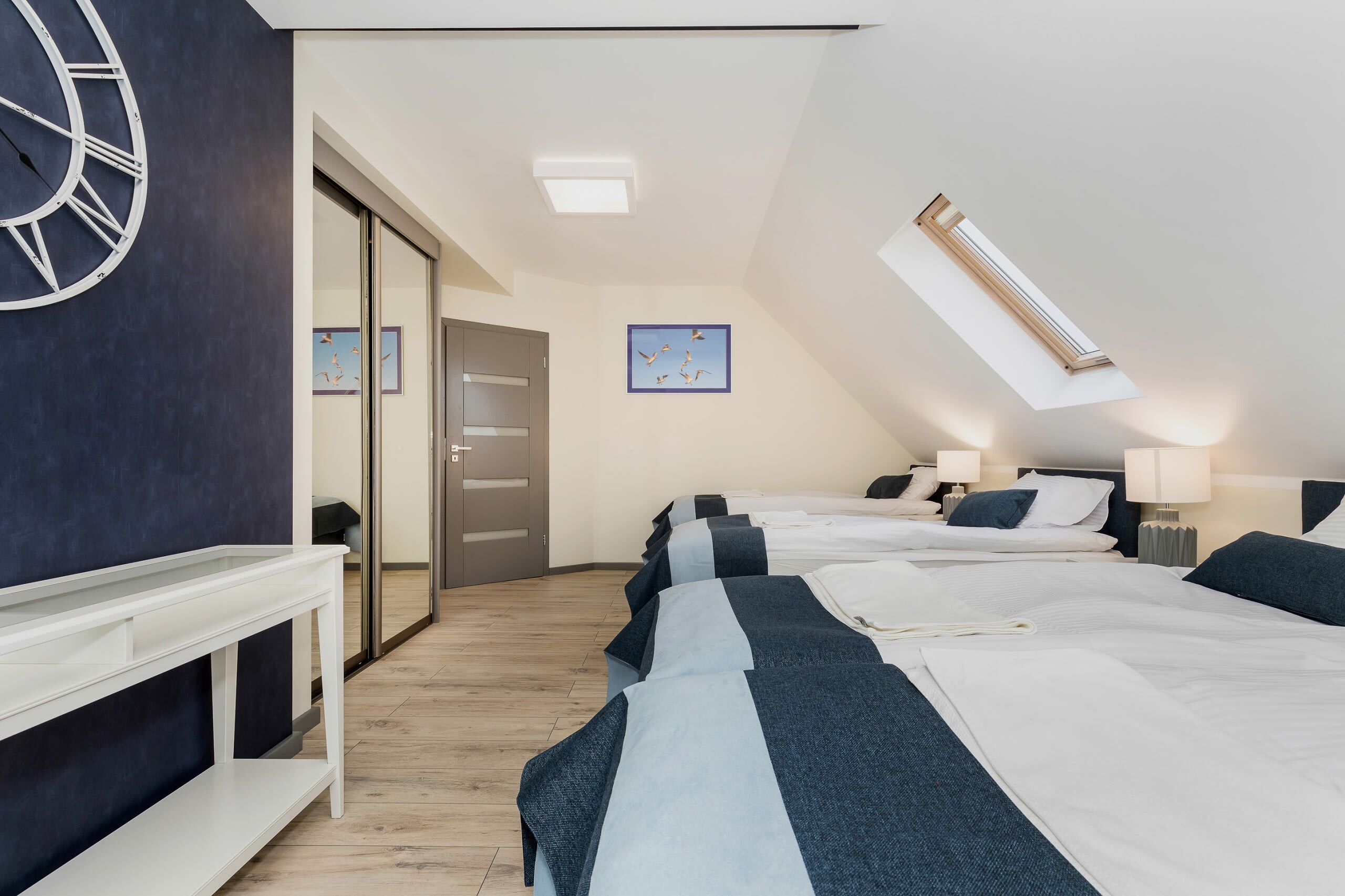 Another modern bedroom featuring a comfortable bed and a sleek, minimalistic design with gray and white decor.