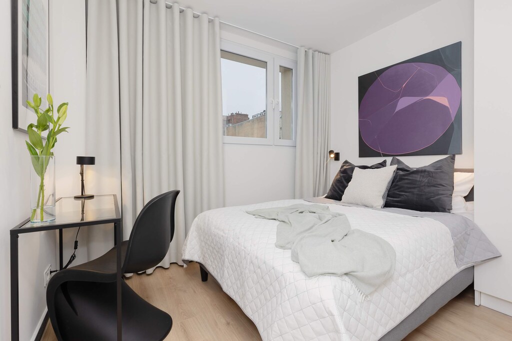 The cosy bedroom features a luxurious double bed and a desk.