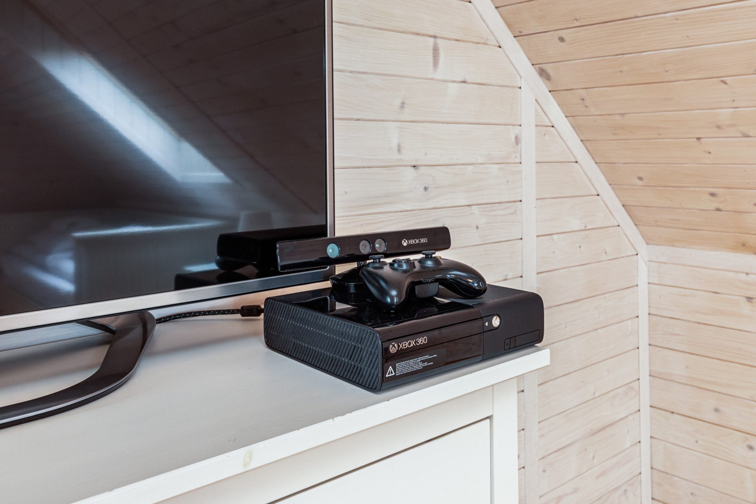 The Xbox game sits on a white cabinet next to the TV.