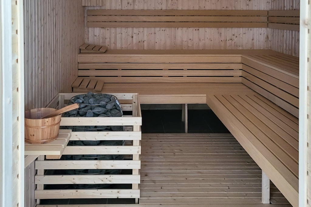 A traditional sauna with wooden benches and cozy lighting for relaxation.