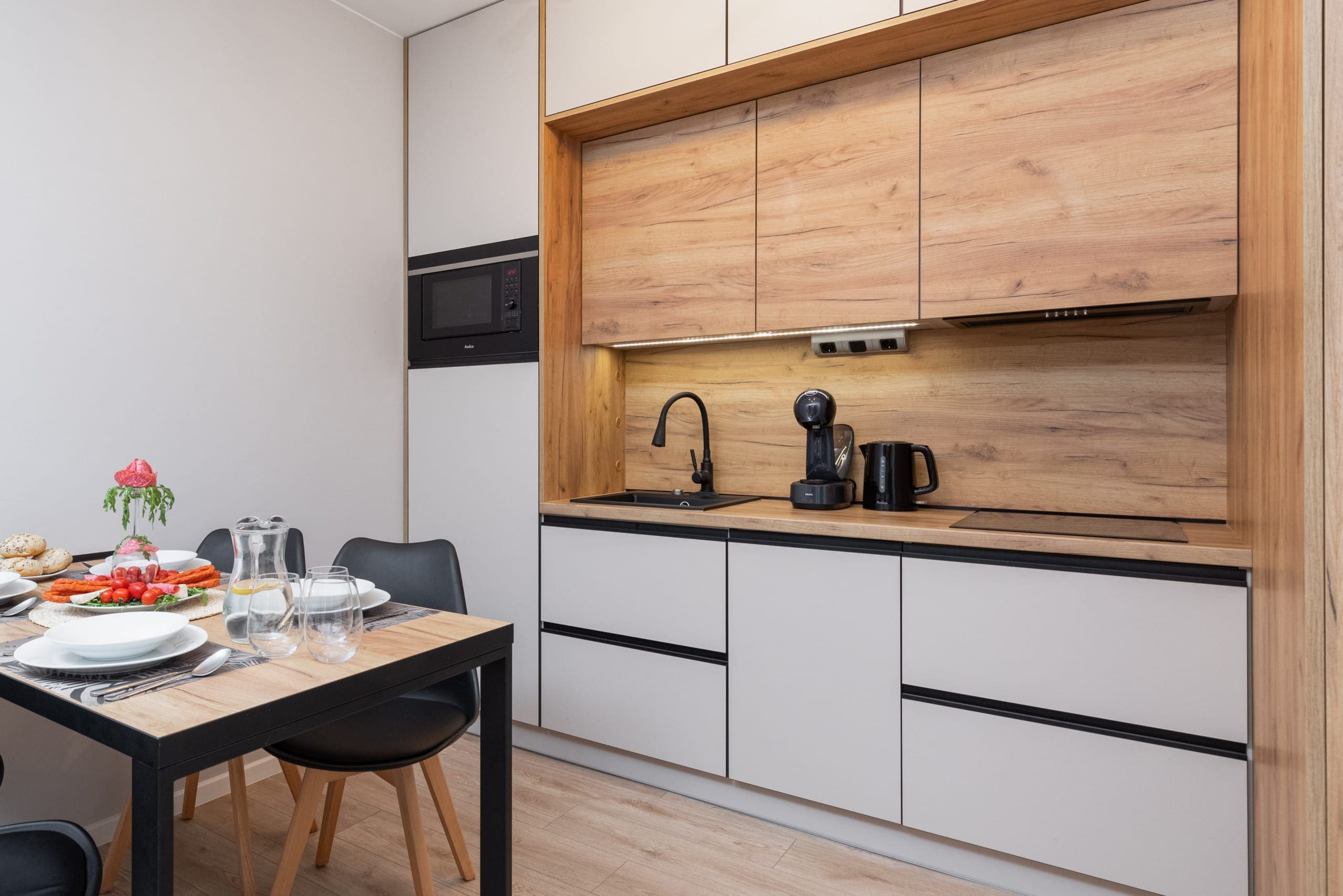 A kitchen with wooden cabinetry and sleek appliances.

