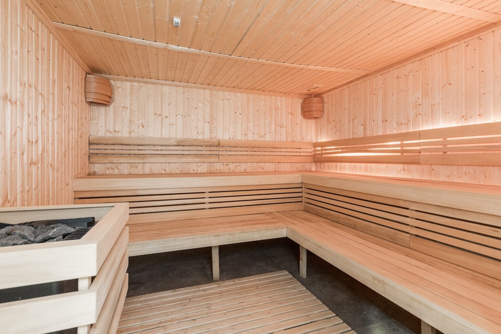 A wooden sauna with warm lighting and a relaxing atmosphere.
