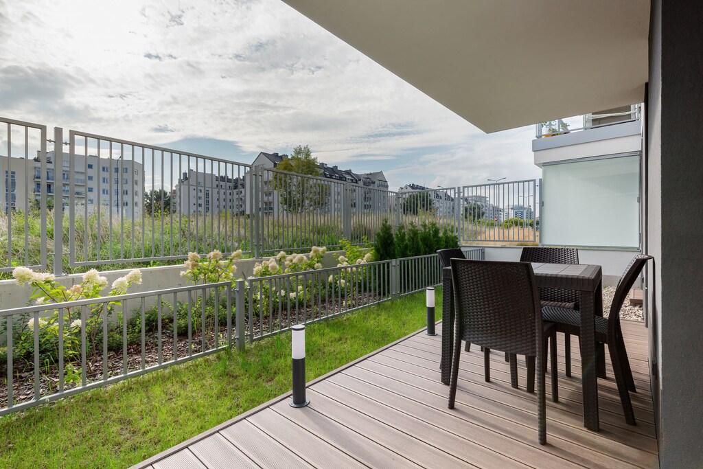 Furnished balcony with green surroundings. 