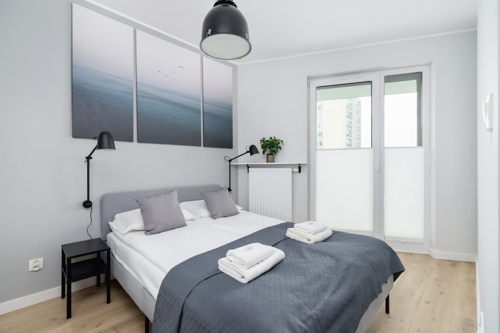 A comfortable bedroom featuring a double bed with black and white decor.
