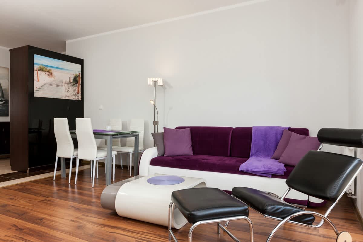 Living room with light-coloured walls and a seating area connected to the dining area.