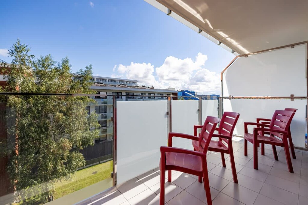 Furnished balcony with green surroundings. 