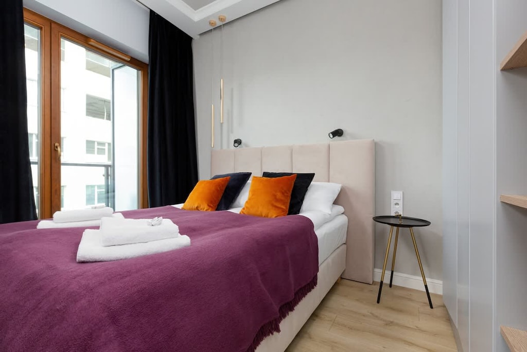 Modern bedroom with a comfortable double bed and wardrobe.