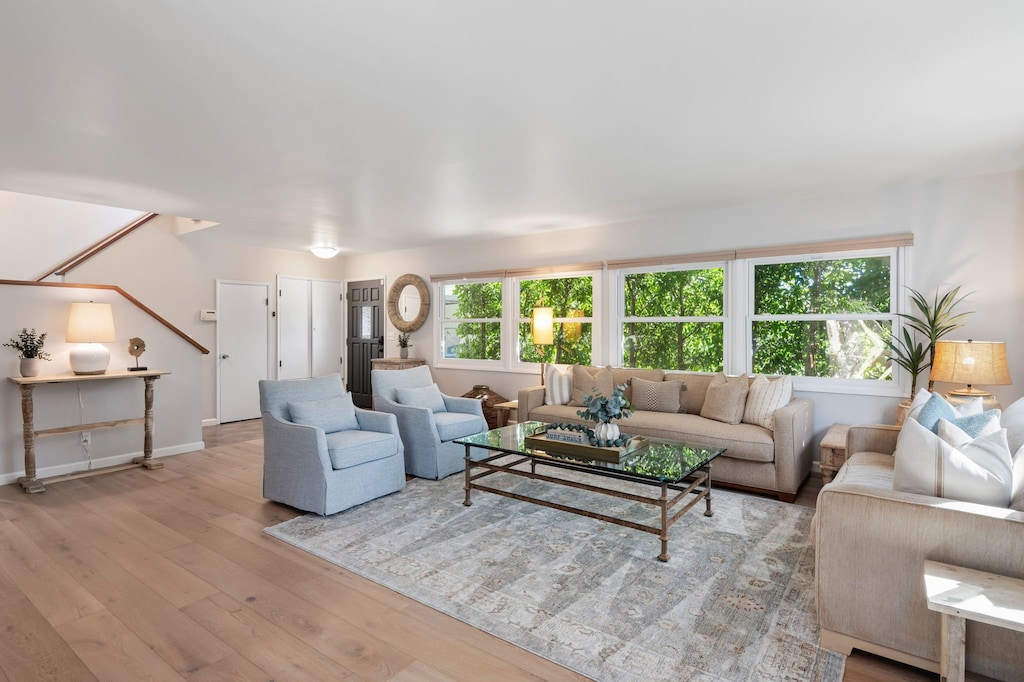 The oversized living space is surrounded by lush greenery