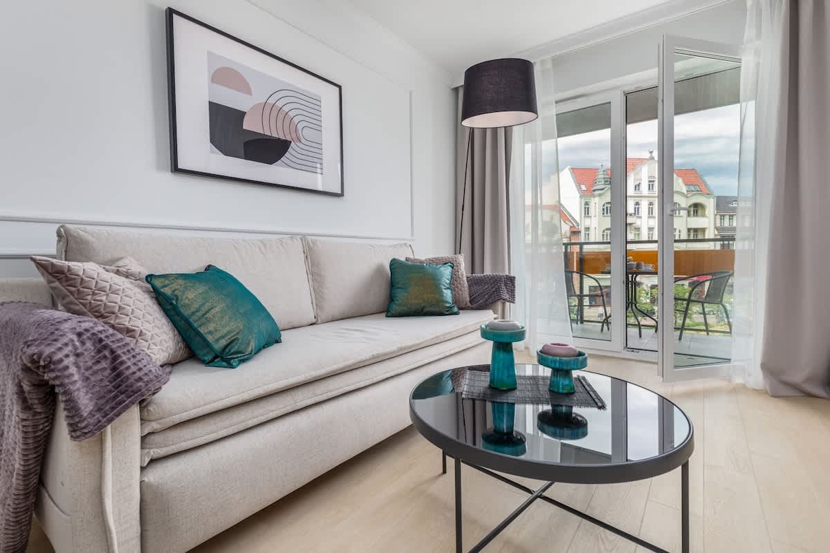 Living room with a sofa bed, coffee table, TV and exit to the balcony