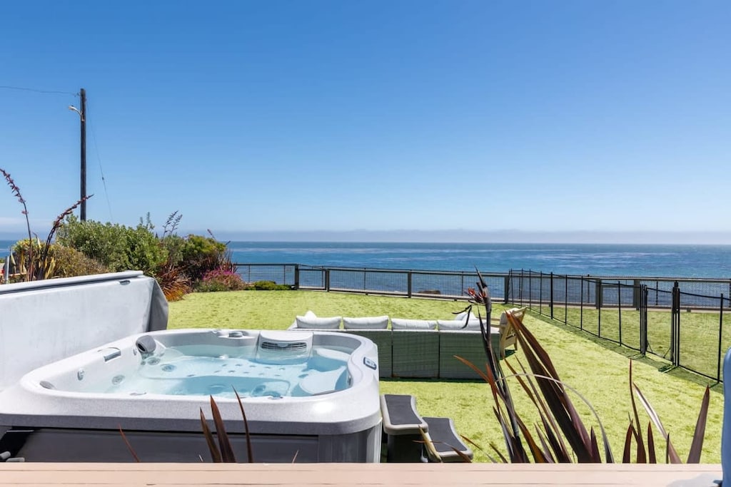Oceanfront backyard with plenty of seating, a hot tub, fire pit, and BBQ!