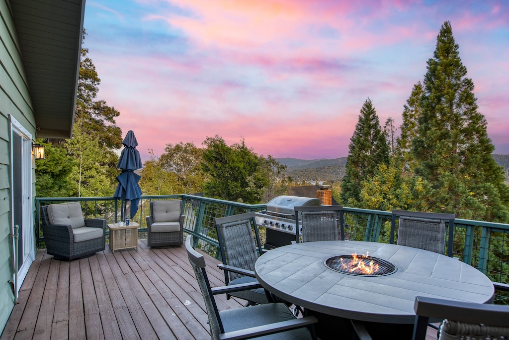 Deck with a fire pit table, grill, and seating area.
