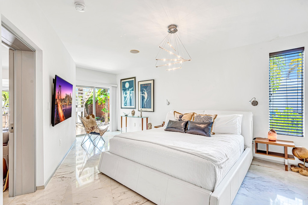 Grand Primary Bedroom with direct pool access, office nook, smart TV, en-suite bathroom featuring a bathtub and walk-in shower.