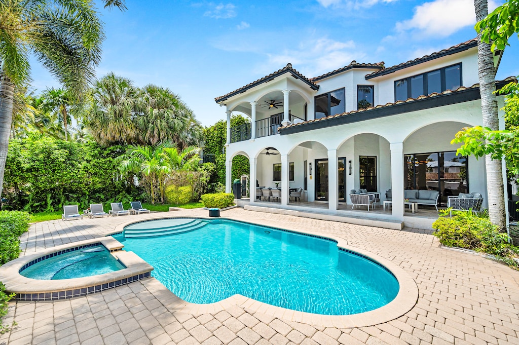 The outdoor covered patio features a lounge and dinning area with access to the heated pool.