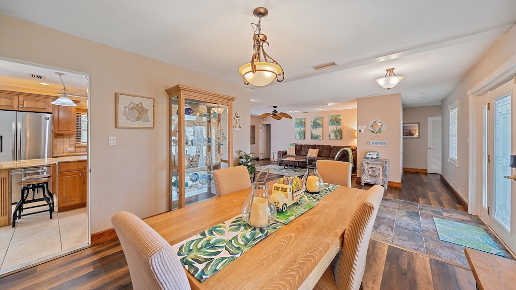 Gather for family meals in the welcoming dining area with coastal decor, offering a bright, seamless flow into the main living room and the kitchen.