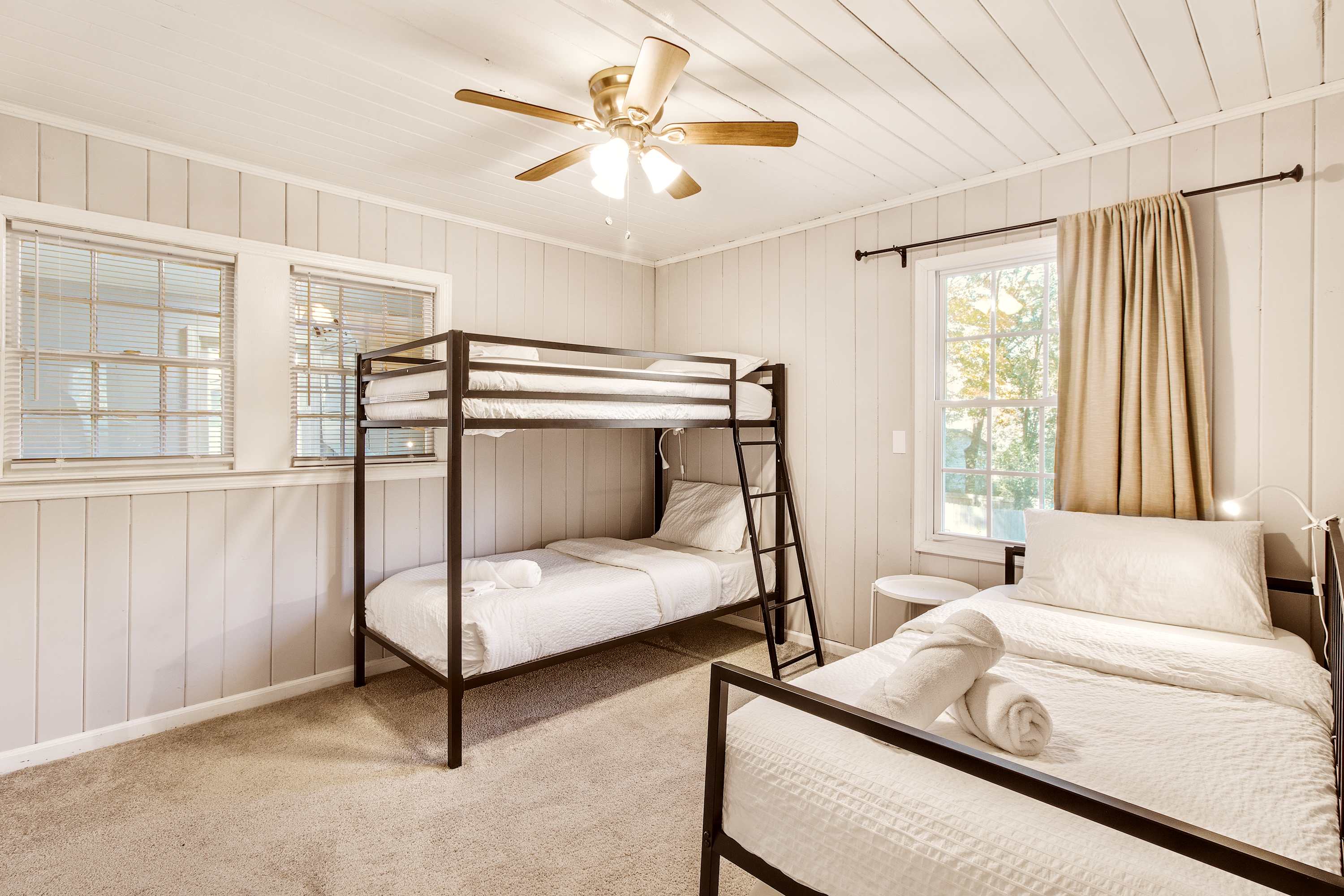 Cozy bedroom with bunk and single beds, perfect for families or groups seeking comfort and convenience. Cozy bedroom with bunk and single beds, perfect for families or groups seeking comfort and convenience.