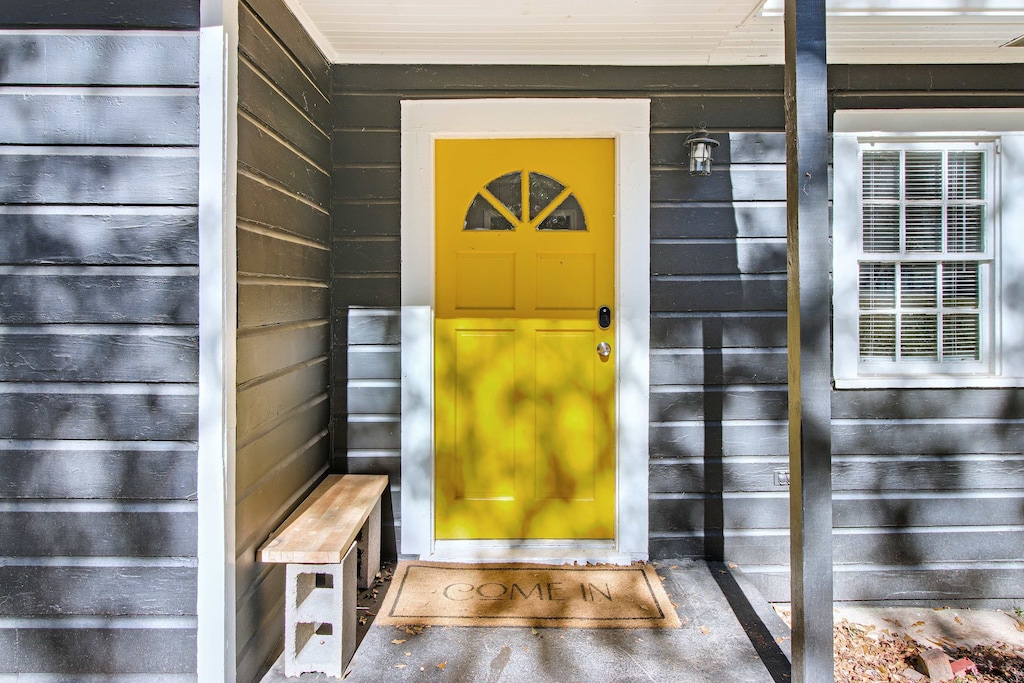 Welcome to your cozy retreat with a charming yellow door and inviting bench. Perfect for a relaxing getaway.