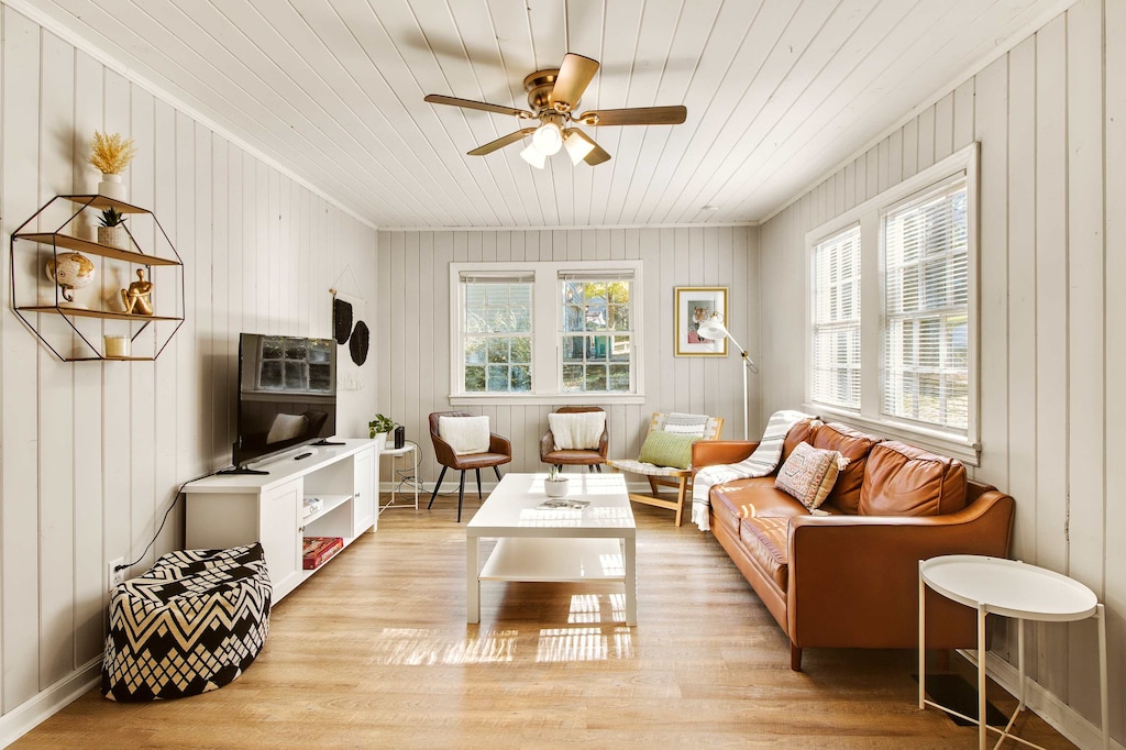 Bright and cozy living room with a stylish leather sofa and ample natural light, perfect for relaxation.