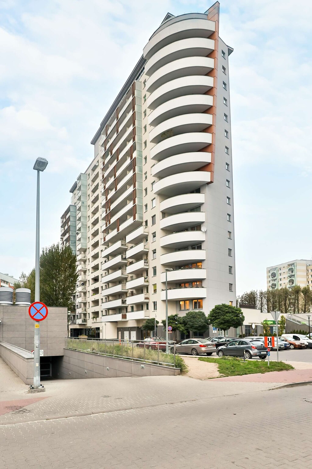 A view of a high-rise apartment building from the outside, capturing the exterior architecture and surrounding street.