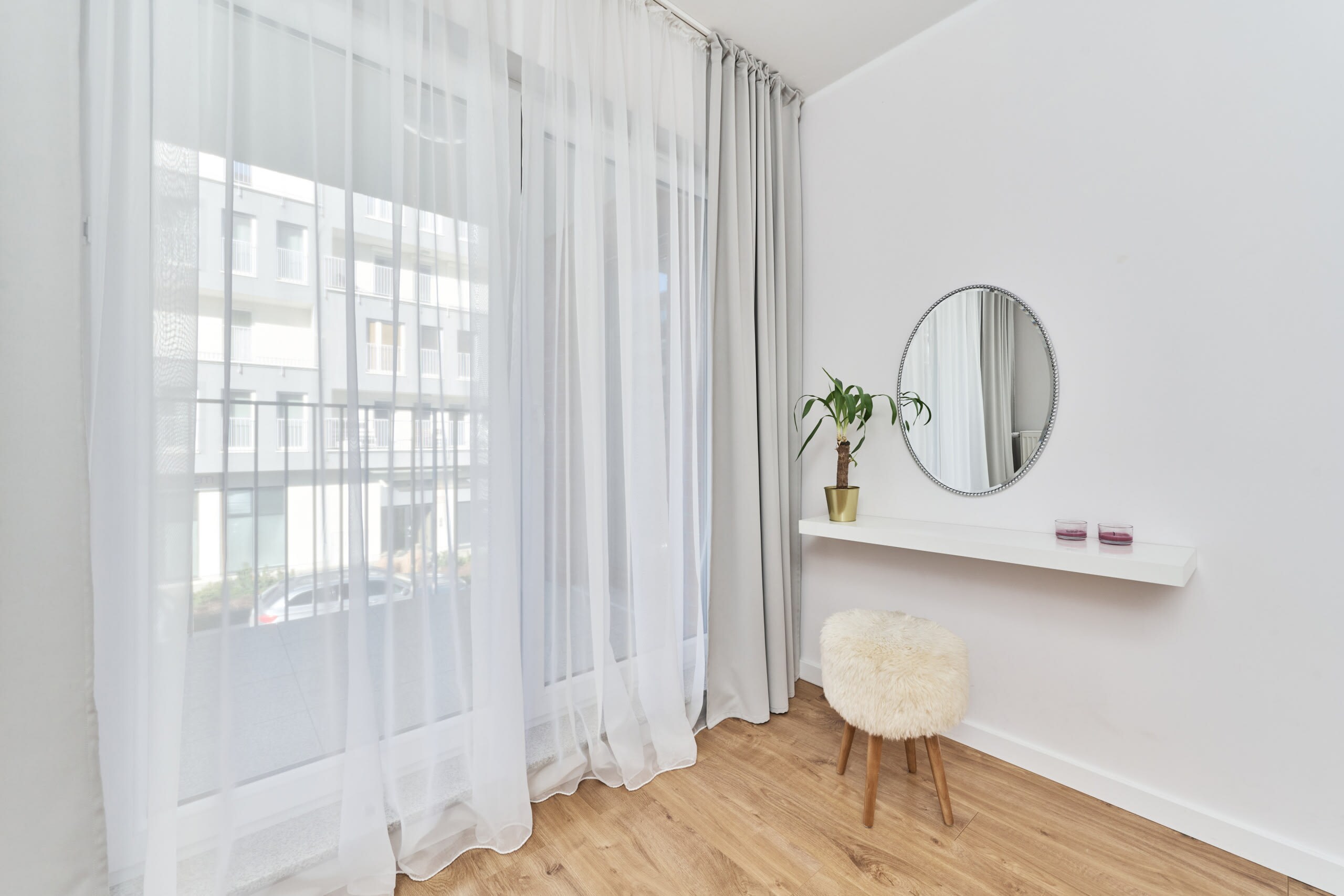  A small entryway with a decorative mirror and minimalistic decor, creating a welcoming feel.