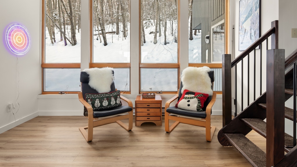 - Bright lounge chairs with snowy forest views through tall windows   - Winter cabin style with cozy throws and festive décor accents   - Perfect corner to relax with coffee or hot chocolate in the snow