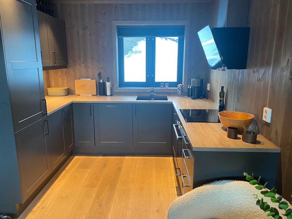 The kitchen is equipped with a refrigerator, oven, dishwasher, and all the kitchenware you'll need. 