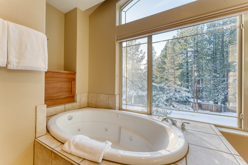 Luxe jetted tub with tree views.