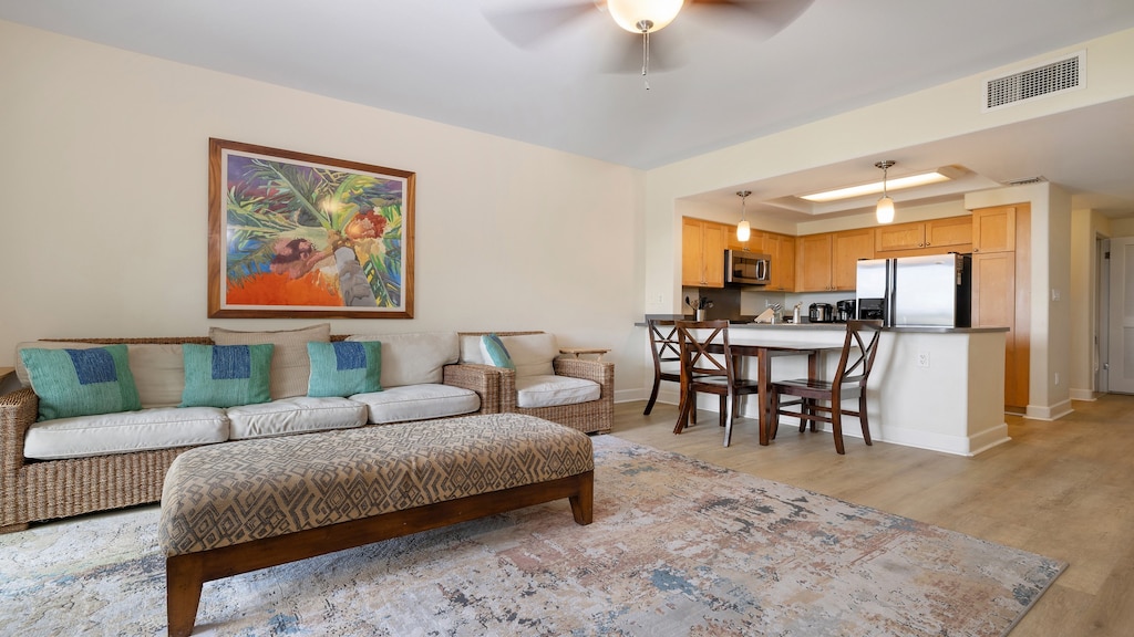 Gather with loved ones in the spacious living and dining area, complete with ceiling fan, natural light, and a welcoming island feel.