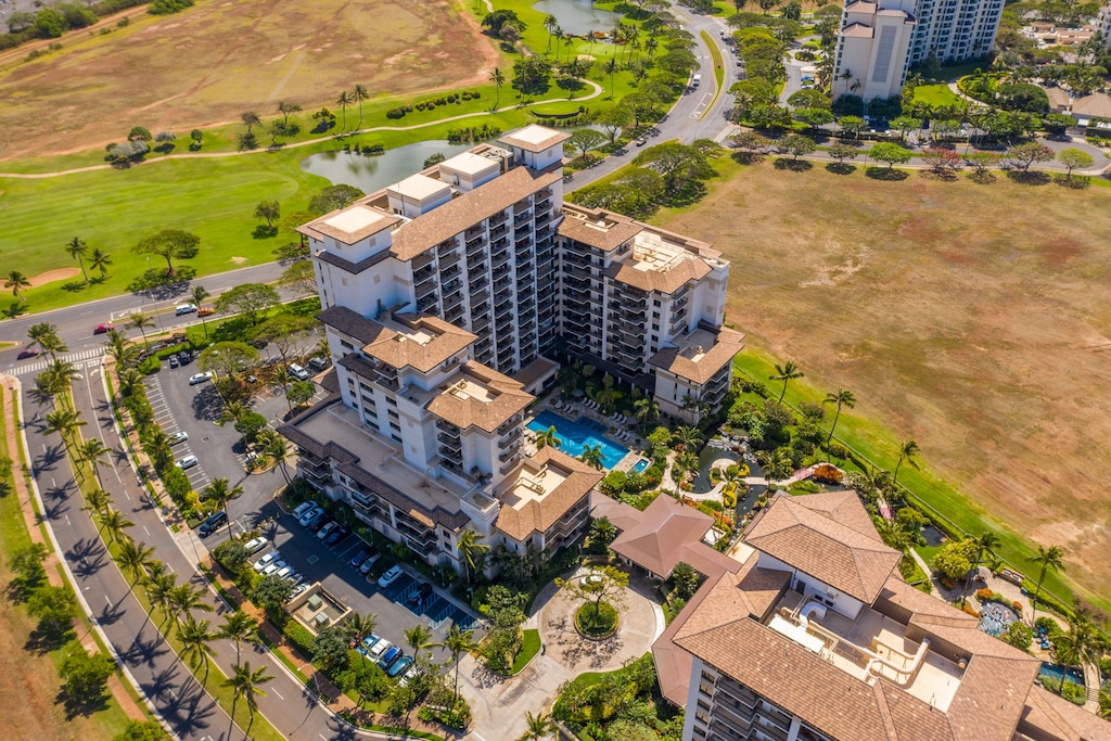 Aerial view of resort property with swimming pool, surrounded by golf course and tropical landscaping.