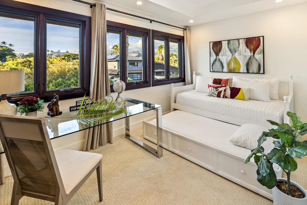 Comfortable den with a trundle bed and a workspace for remote work.