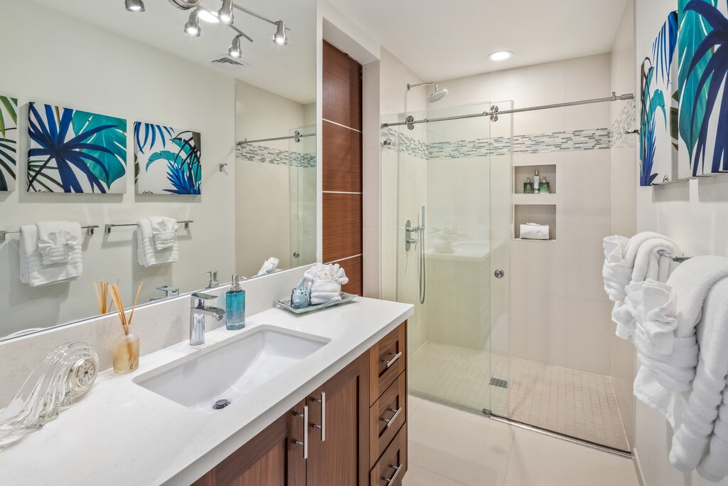 The downstairs guest room has an ensuite with a sleek vanity and glass shower.