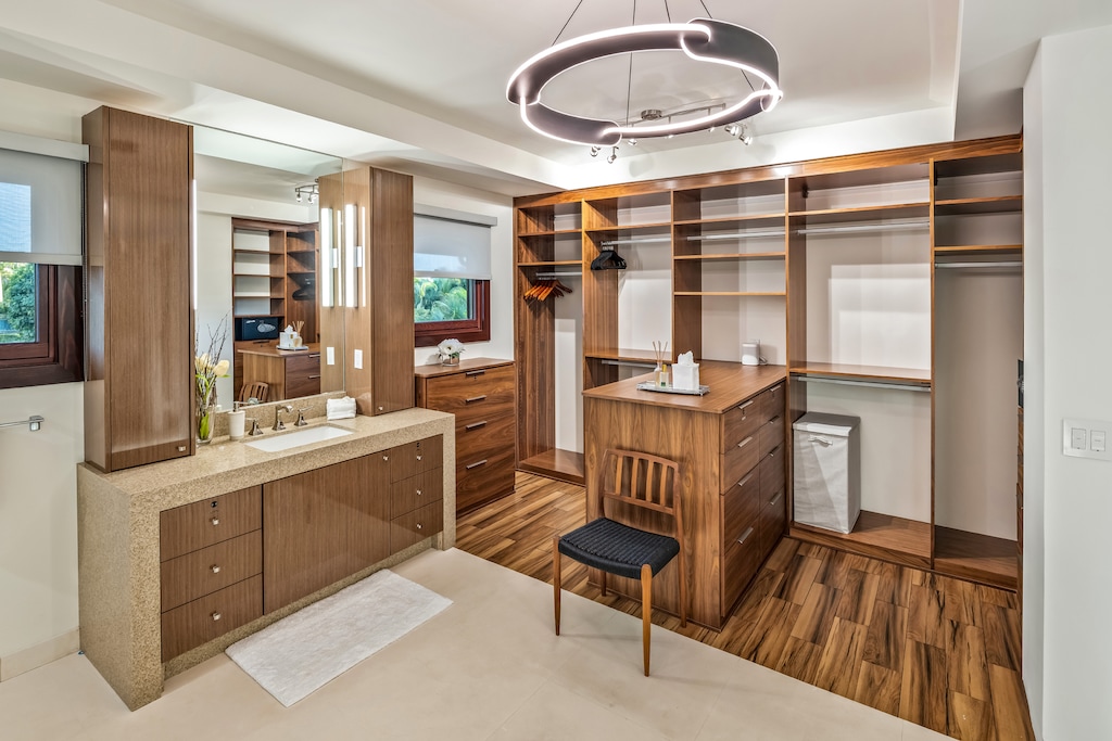 Custom-built primary suite closet with a vanity and storage.