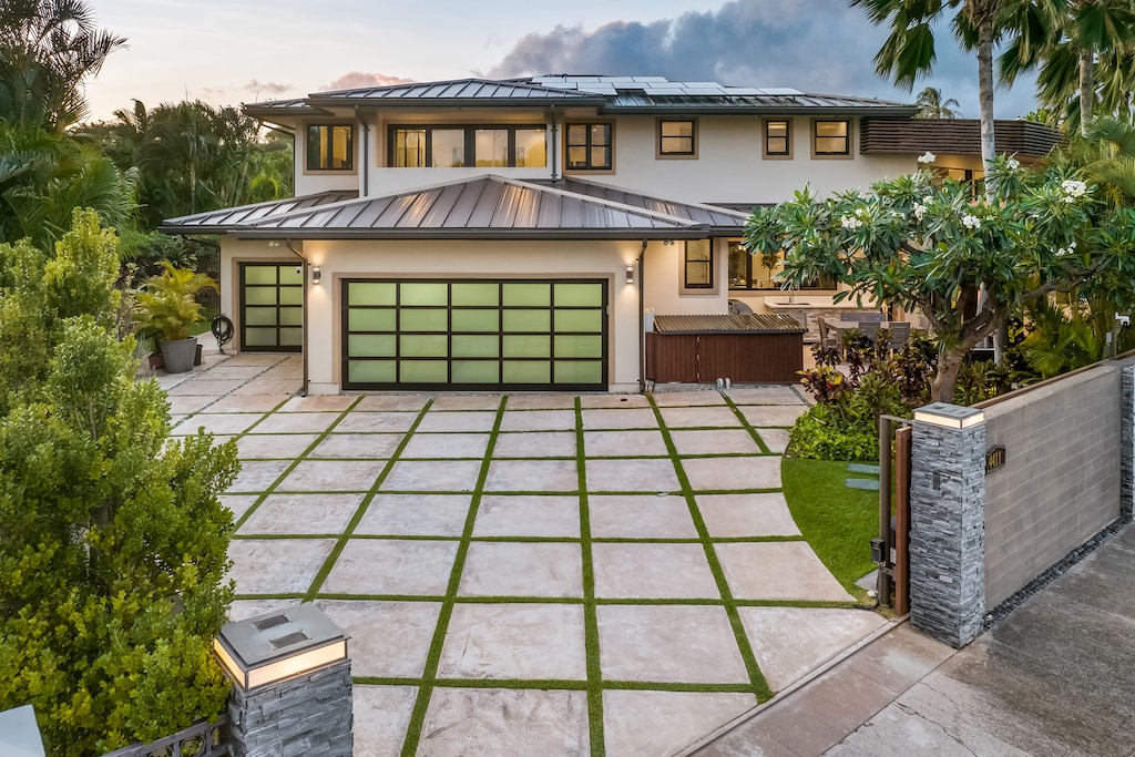 The grand driveway and modern garage showcase the home's sophisticated design.