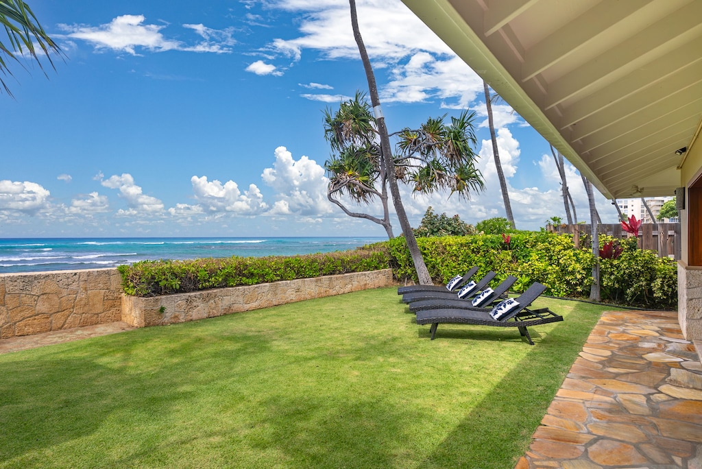 Shaded oceanfront lounging area tucked beneath swaying palms—your private slice of paradise.