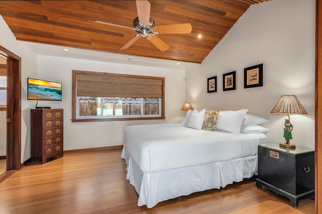 Second bedroom with vaulted ceiling, king bed, and warm wood tones for a relaxing retreat.