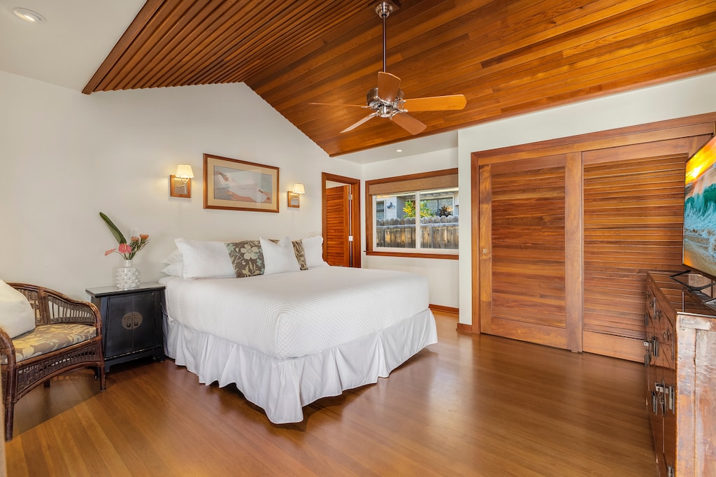 Serene primary bedroom with a king-size bed and hardwood floors, creating a peaceful island retreat.