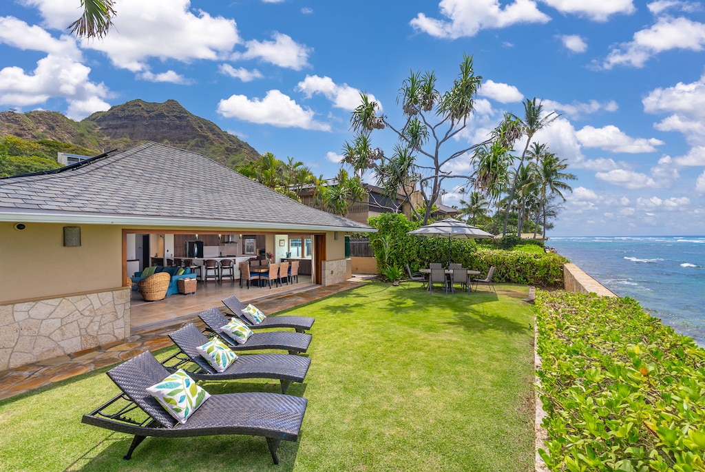 Lush grassy lawn with cushioned loungers offers a peaceful space to soak in ocean views and tropical breezes.