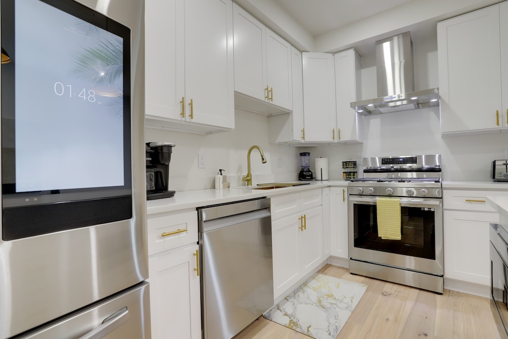 Modern kitchen with a digital refrigerator, dishwasher, oven, range and microwave. 