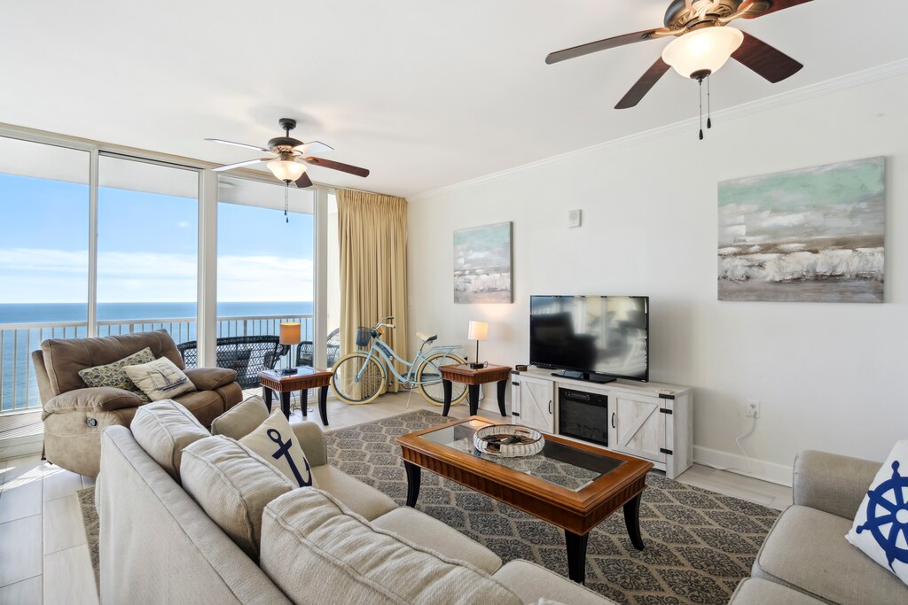 Living room with balcony access and a large flat-screen TV