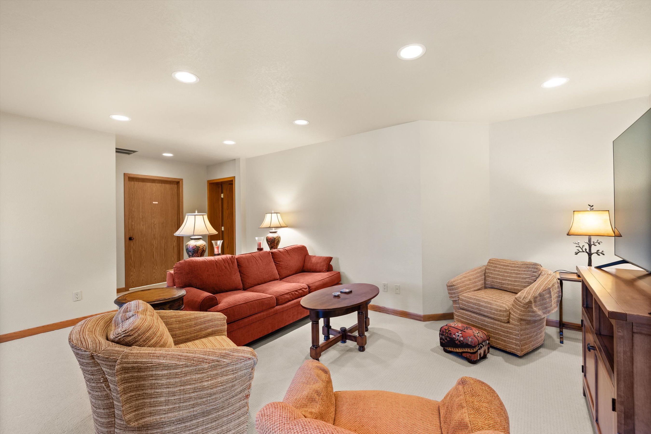 Settle into your spacious living room where warm earth tones and comfortable seating create the perfect spot for relaxing evenings. The thoughtful lighting and cozy furnishings make this your home away from home.