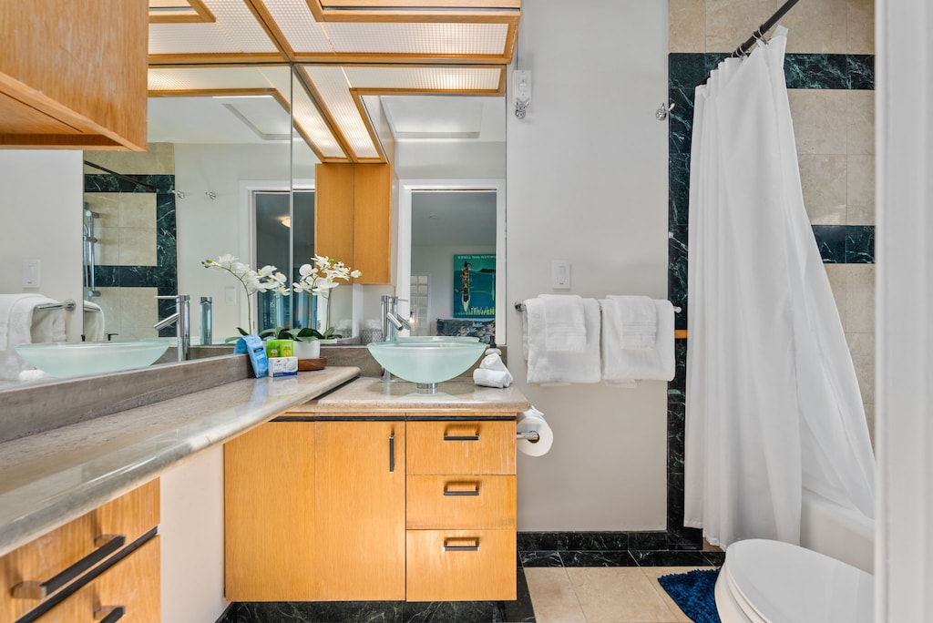 Private guest ensuite with sleek vanity and glass-enclosed shower.