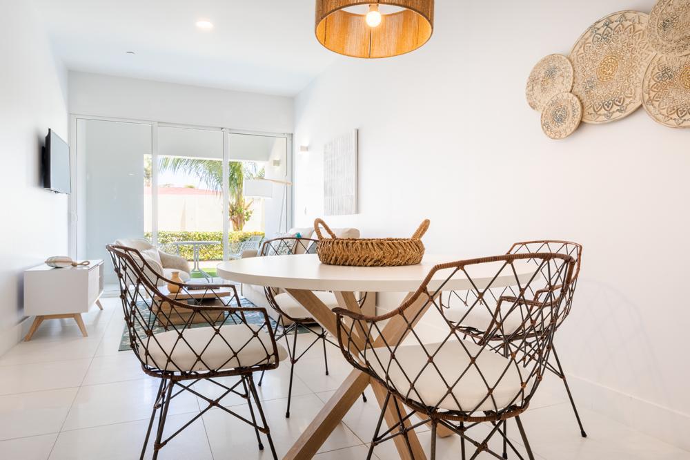 Modern dining space with stylish seating & a warm, inviting atmosphere for shared meals - Seamless open layout connects with the living area, creating a spacious &  airy feel - Glass doors let in natural light, making every meal bright & refreshing