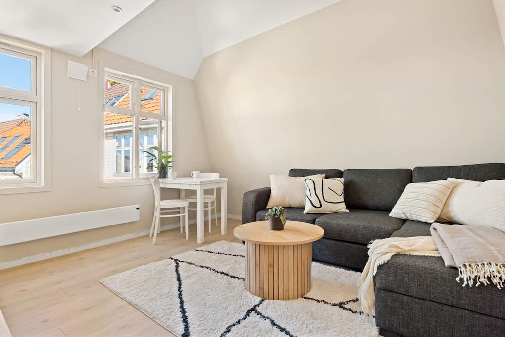 Koselig spiseplass med et lite bord ved vinduet, perfekt for å nyte måltider med naturlig lys og en fin utsikt.