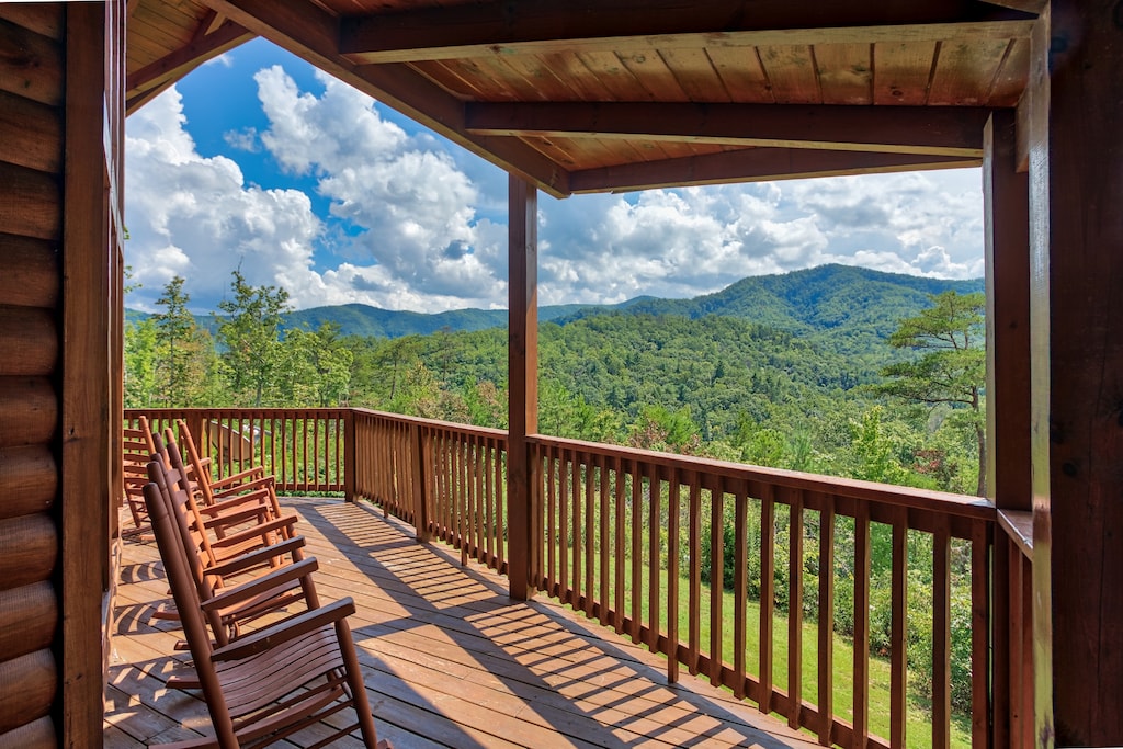 Rocking chairs on the covered deck with mountain views at Four Seasons Lodge, a 3-bedroom cabin rental located in Pigeon Forge